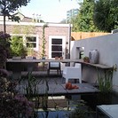 Tuin 3.6 moderne tuin met strakke muur en vijver